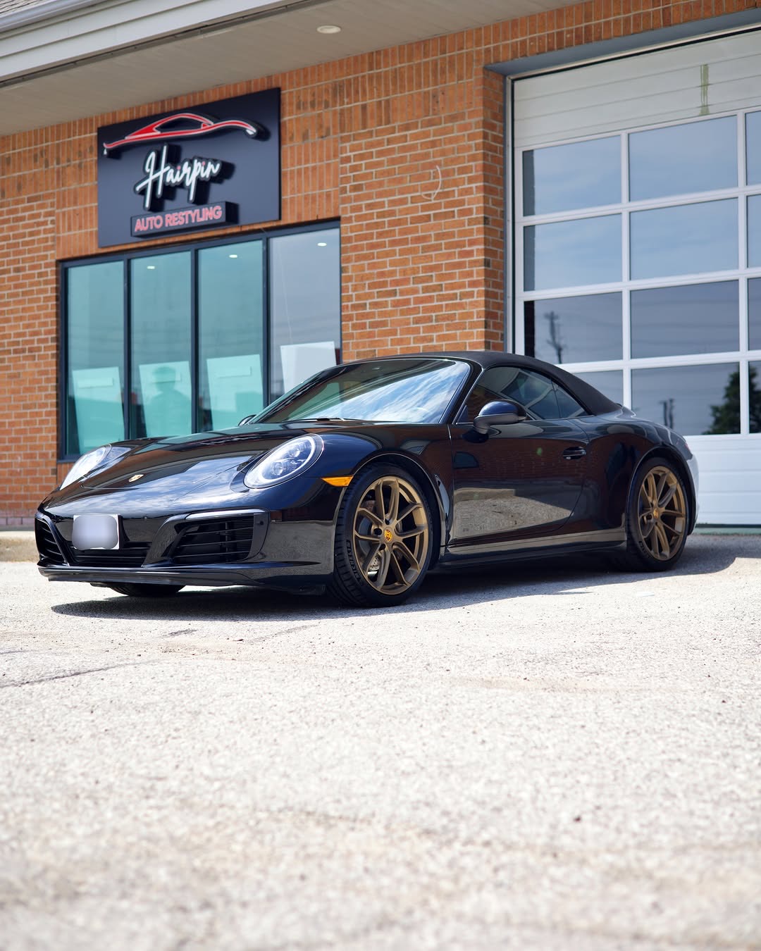 Hairpin Auto Restyling storefront glass with a Porsche 911 parked outside