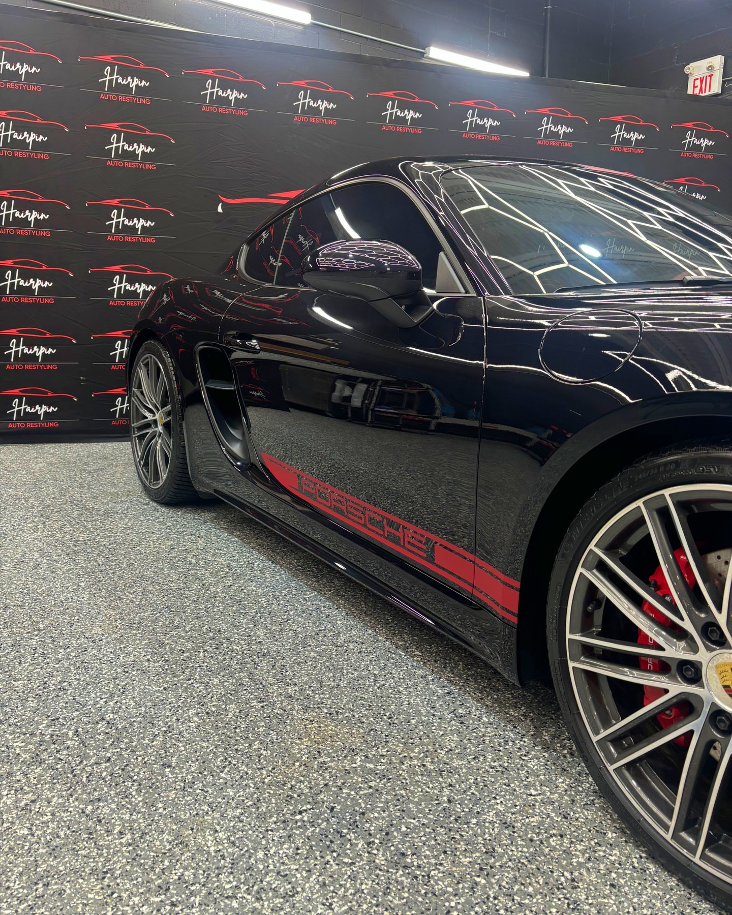 Black Porsche 718 side profile with red Porsche graphics