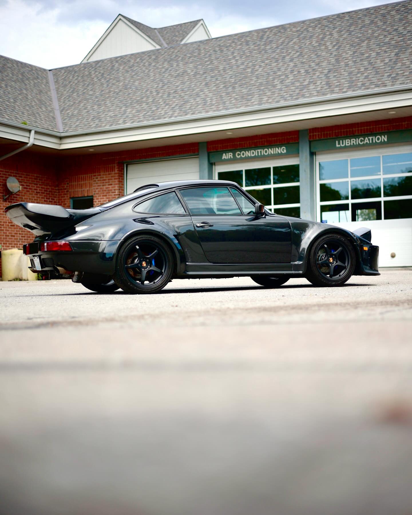 Black classic Porsche 911 Turbo side profile with whale tail spoiler