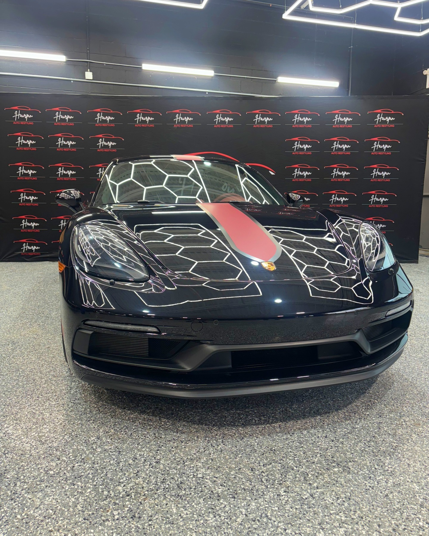 Black Porsche 718 front end under studio hex lighting